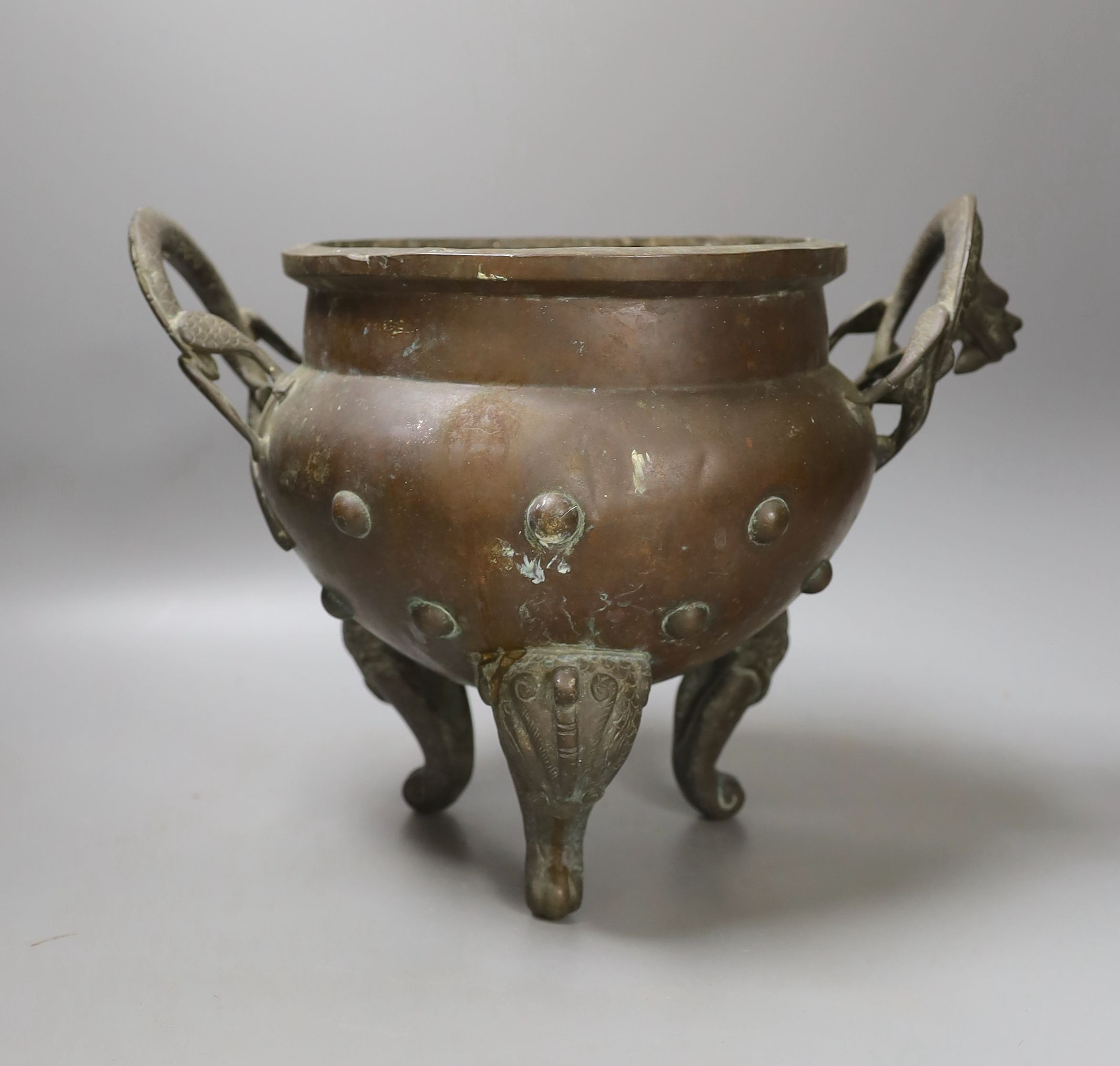 An Oriental two handled elephant footed bronze bowl, 24 cms high not including handles.